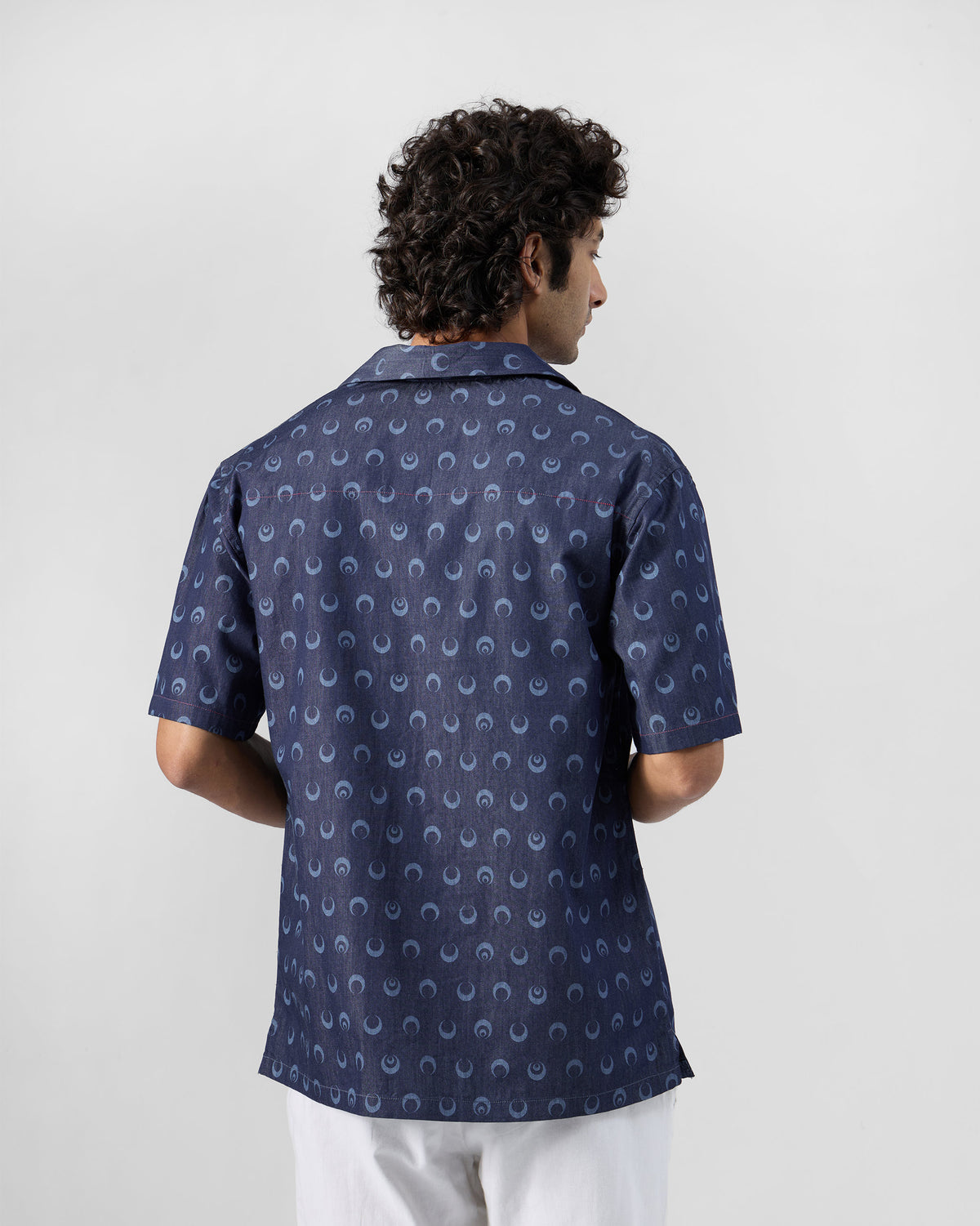 Back of an indigo Yamuna kurta shirt with crescent moon print.