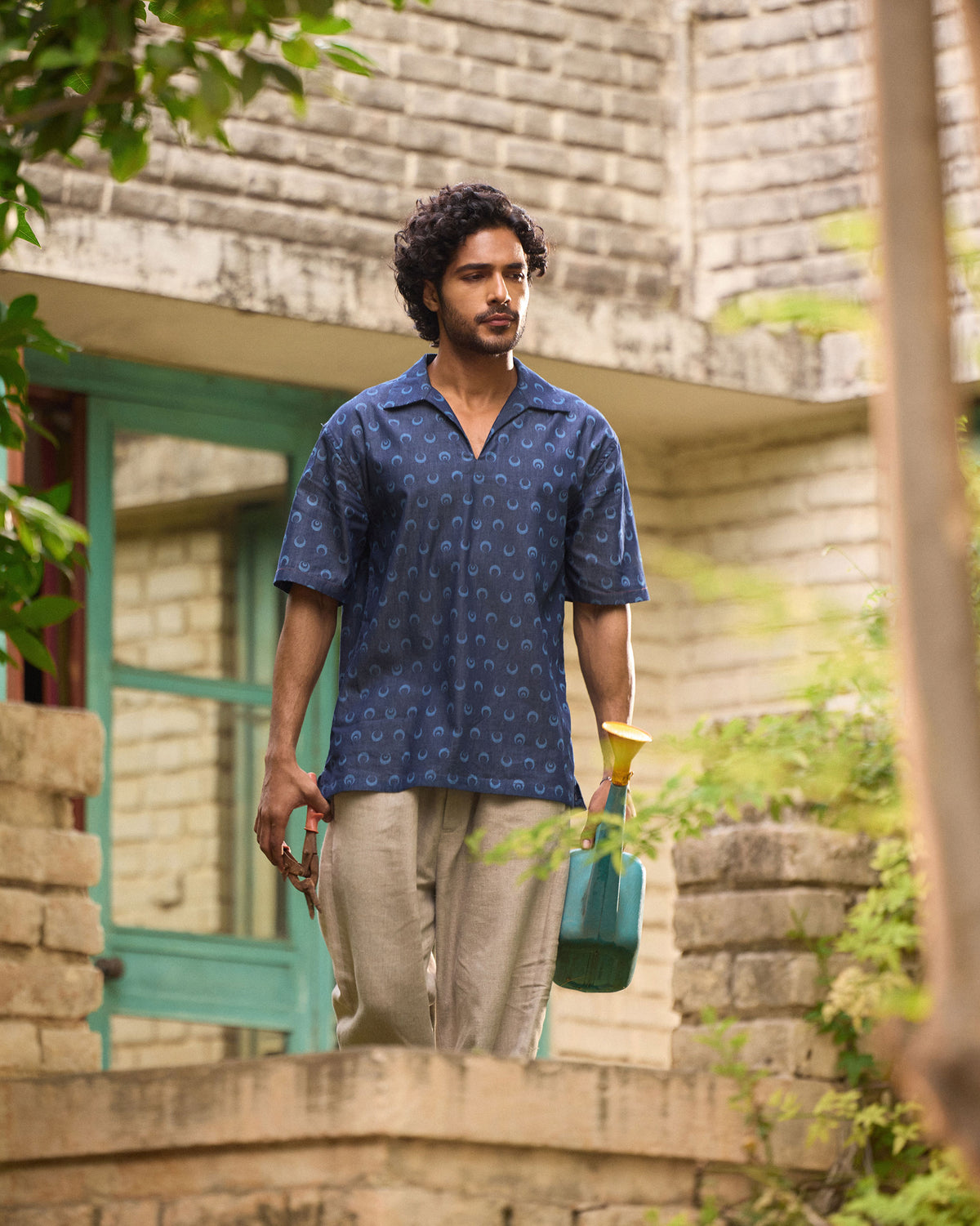 Person wearing an indigo Yamuna kurta shirt with crescent moon print outdoors.