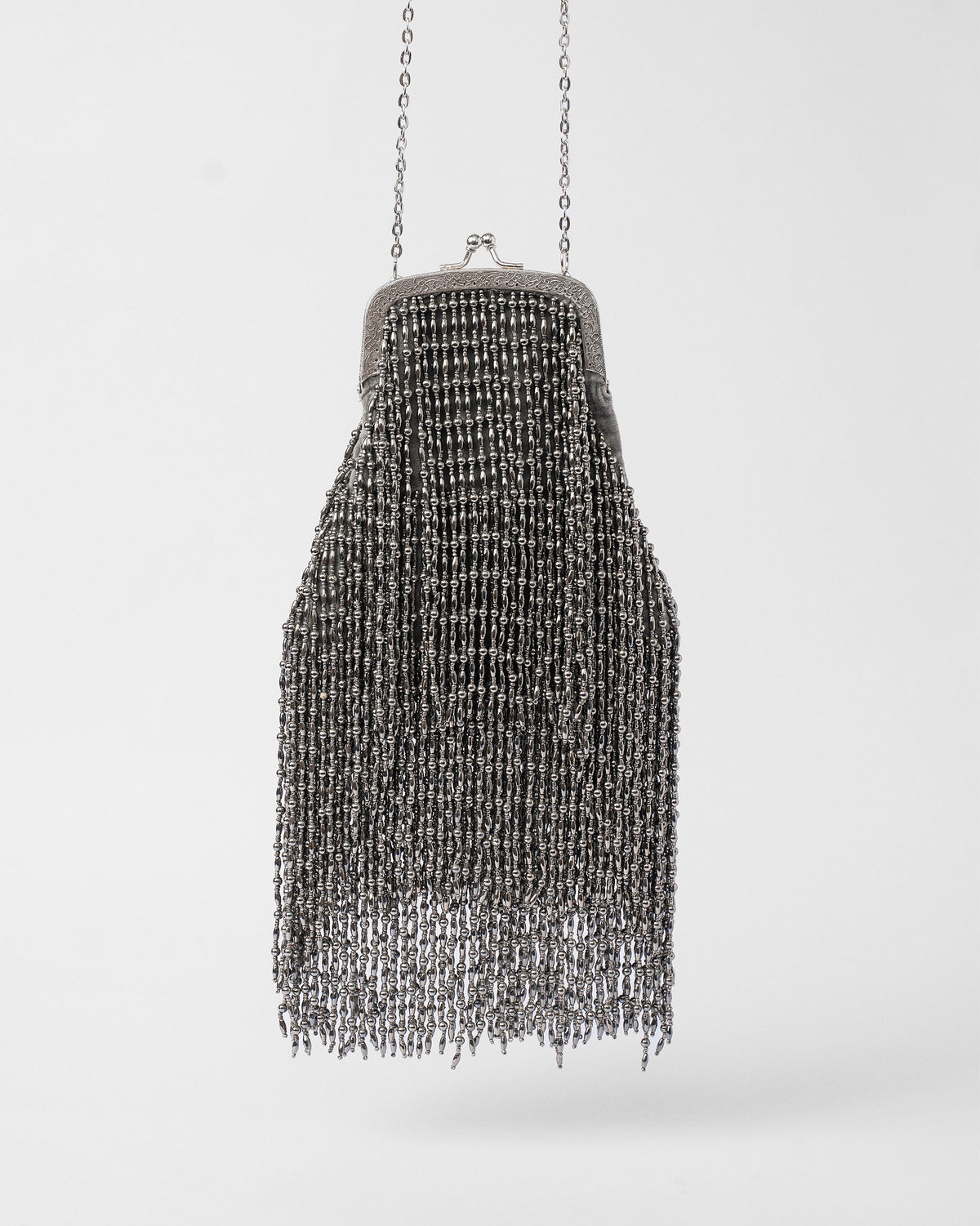 Silver beaded fringe clutch with a kiss-lock frame and chain strap.