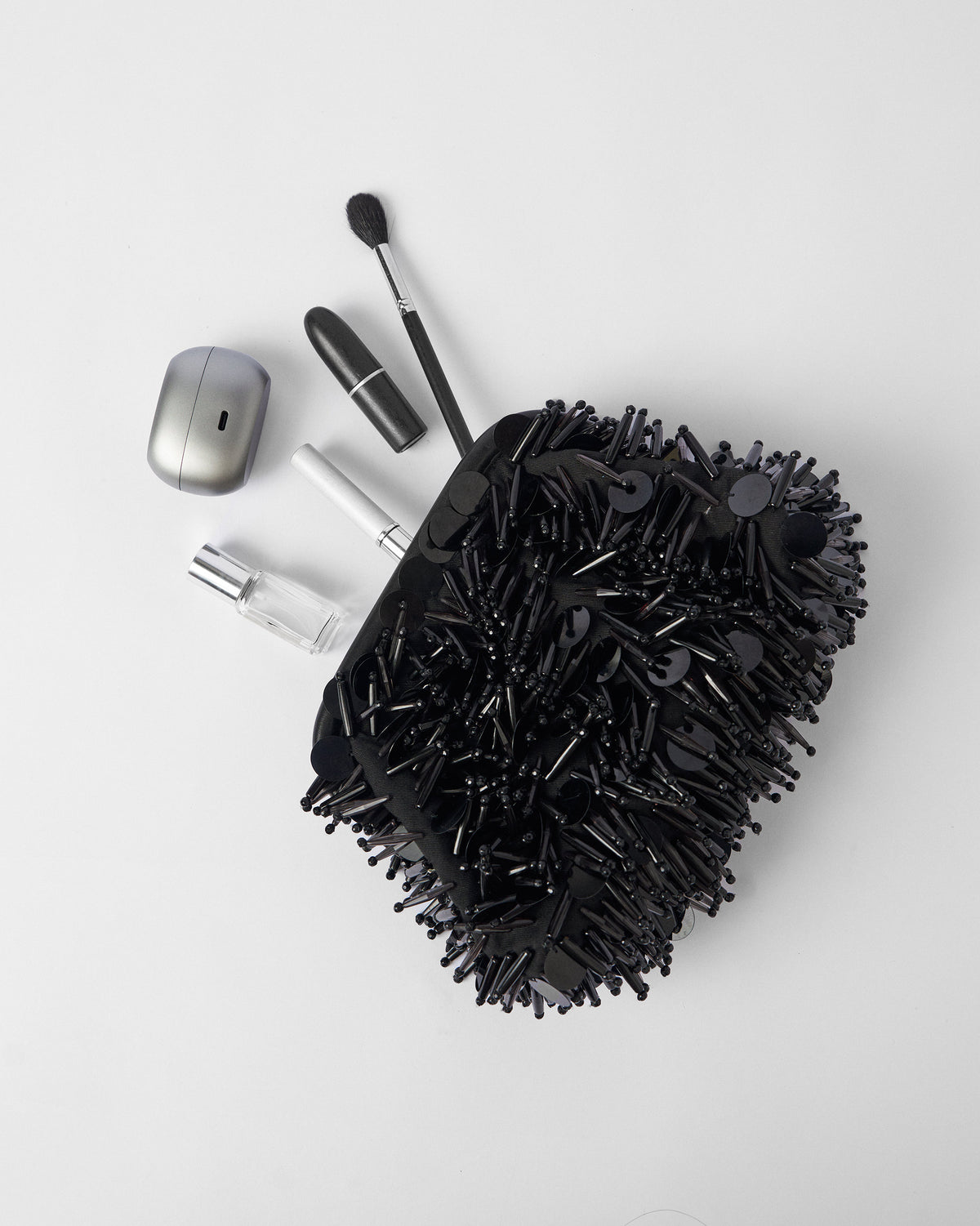Black Starry Night Clutch with lipstick and small essentials spilling out.