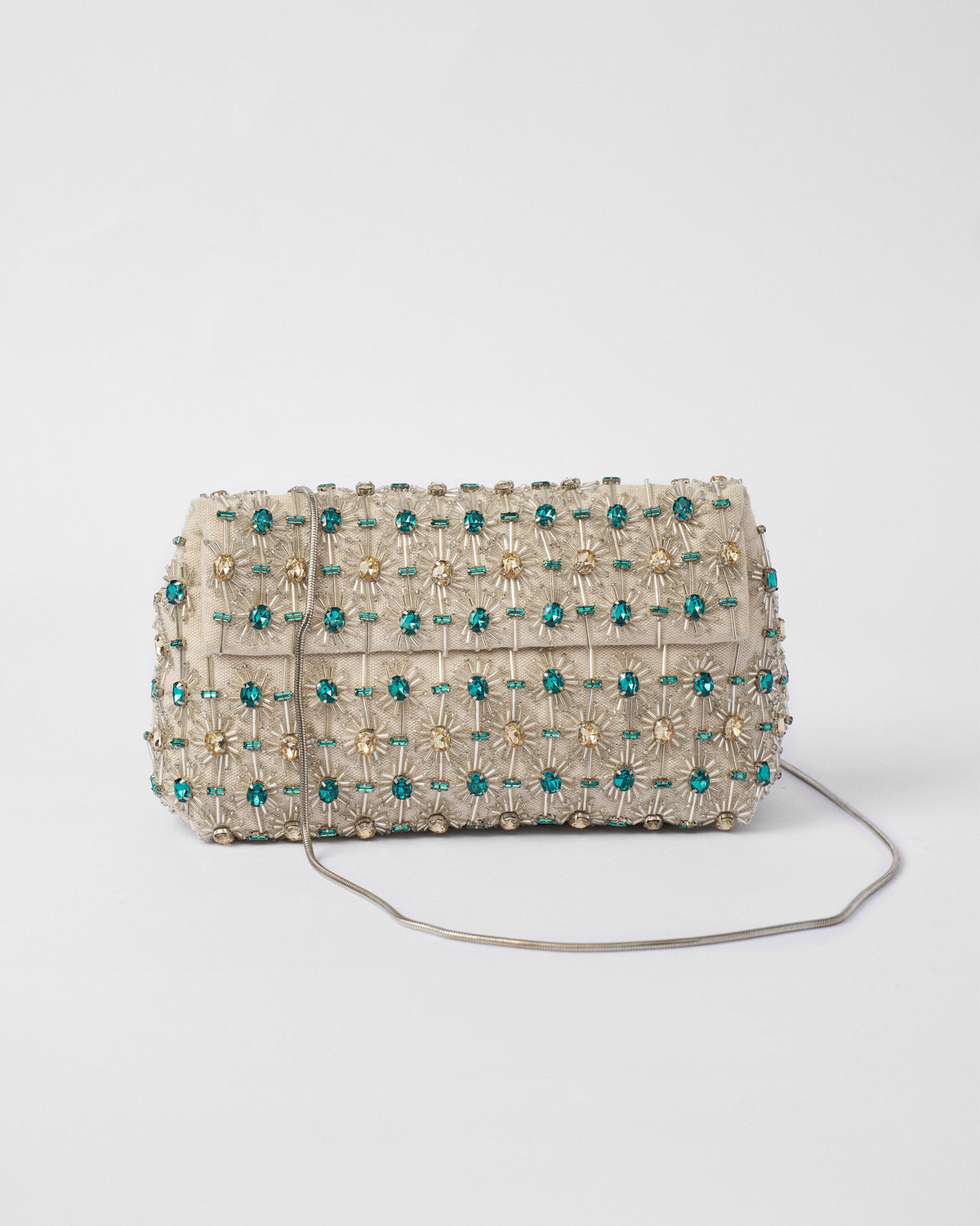Ivory Noor Clutch with teal gem starburst beadwork and a silver chain.
