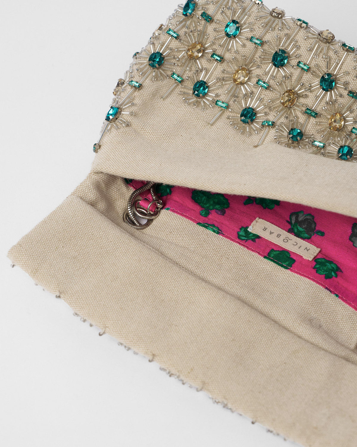 Open ivory Noor Clutch showing a magenta floral lining.