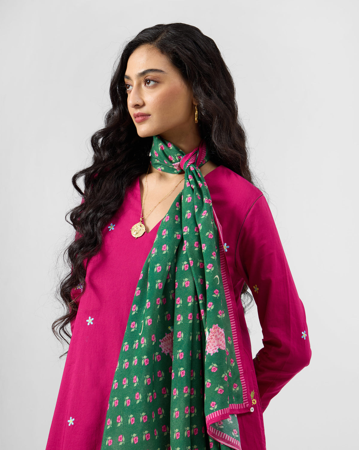 Person wearing a green Gulnaar scarf with a pink floral print.
