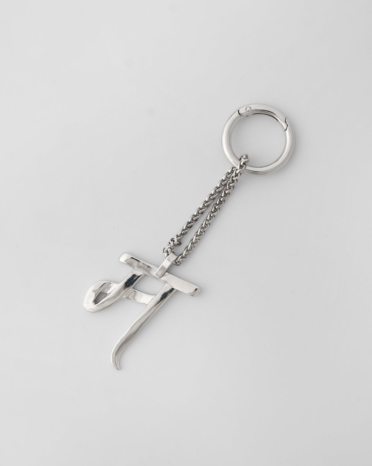 Alphabet M Bag Charm in silver, with chain and clasp ring on a light background.