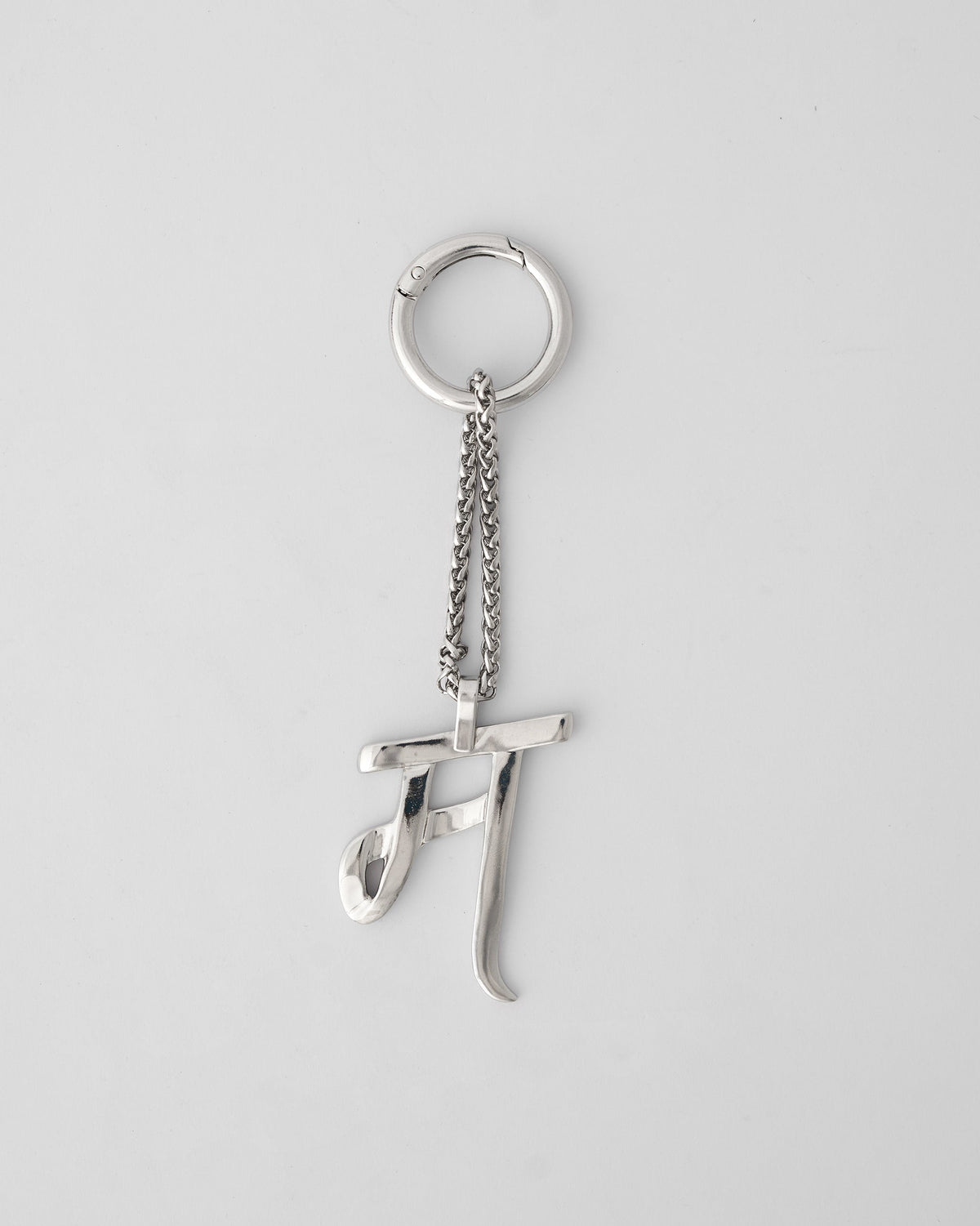 Silver Alphabet M bag charm hanging from a carabiner ring.