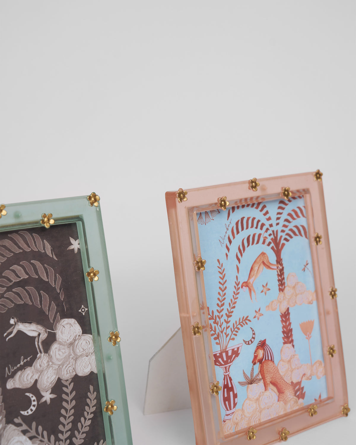 Close-up of a blush Memoir frame with gold flower studs along the border.