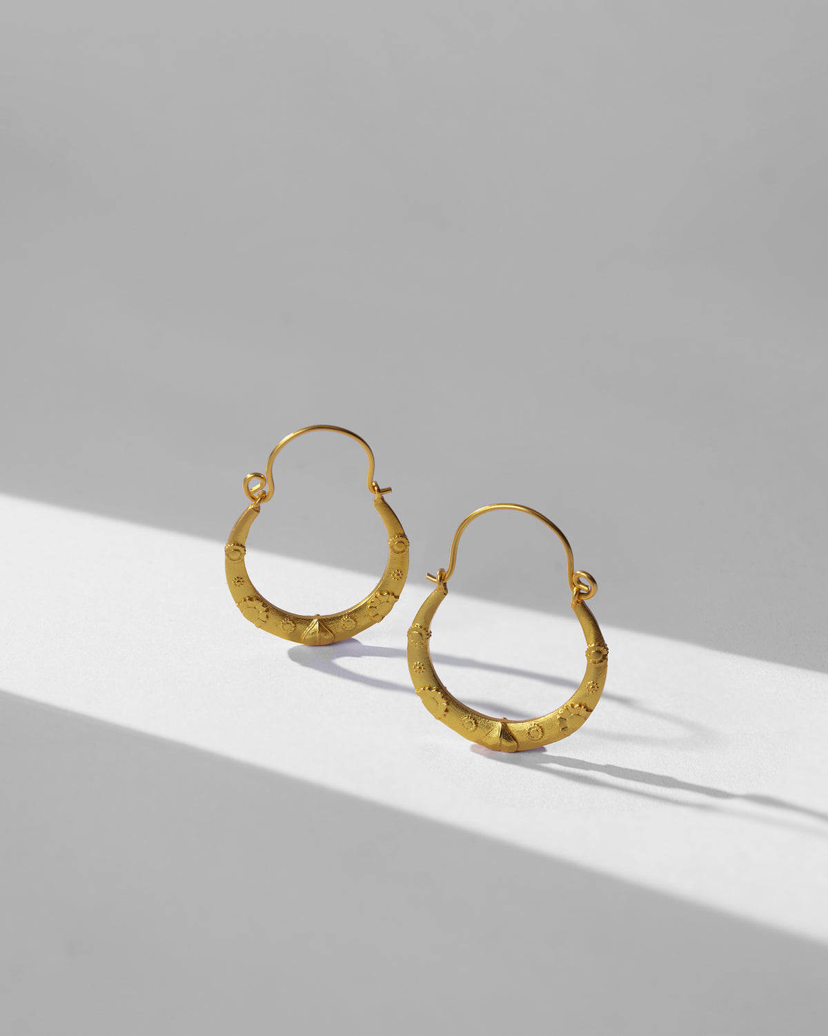 Gold ellora balis standing to show their tapered embossed form.
