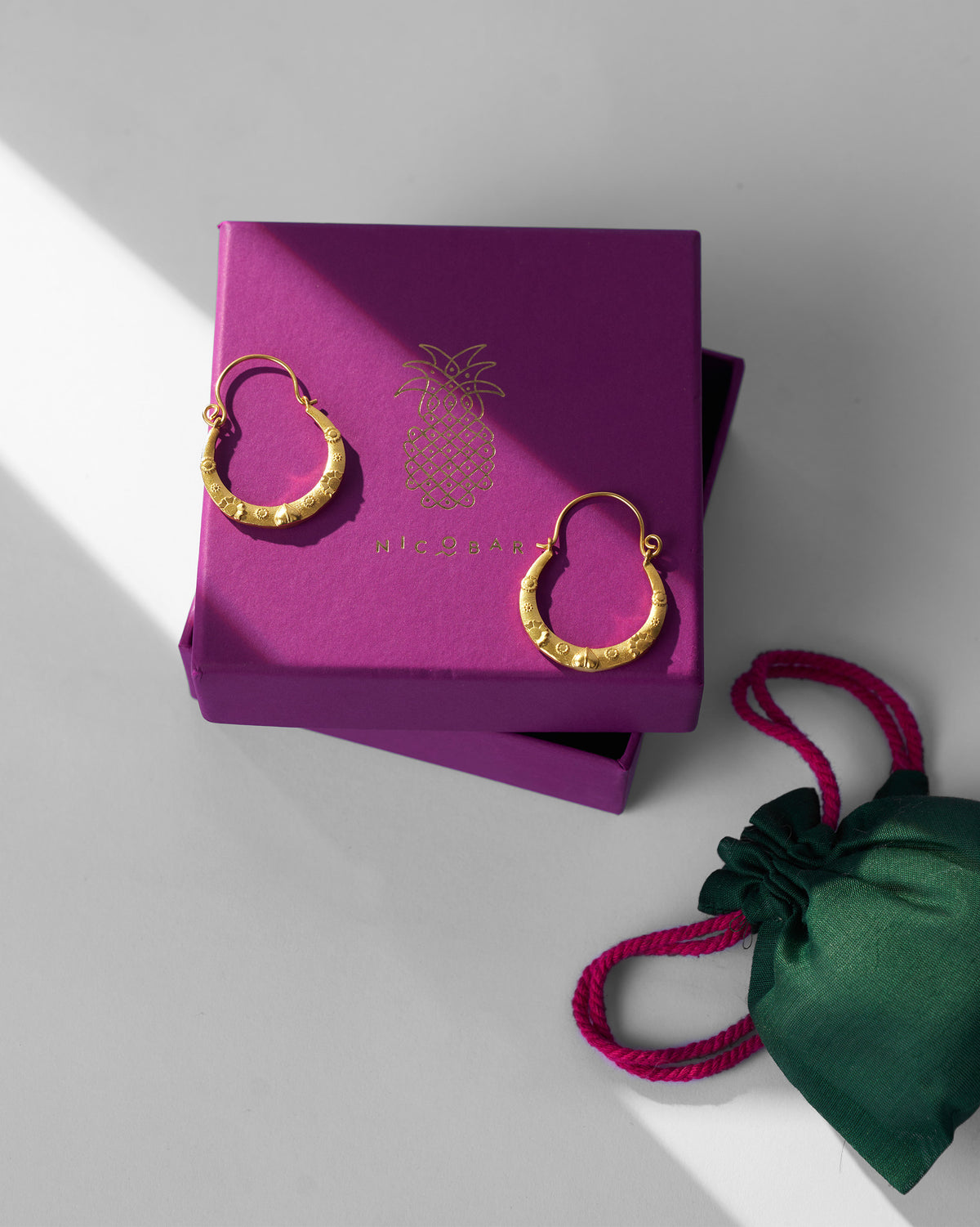 Gold ellora balis on a purple Nicobar gift box.