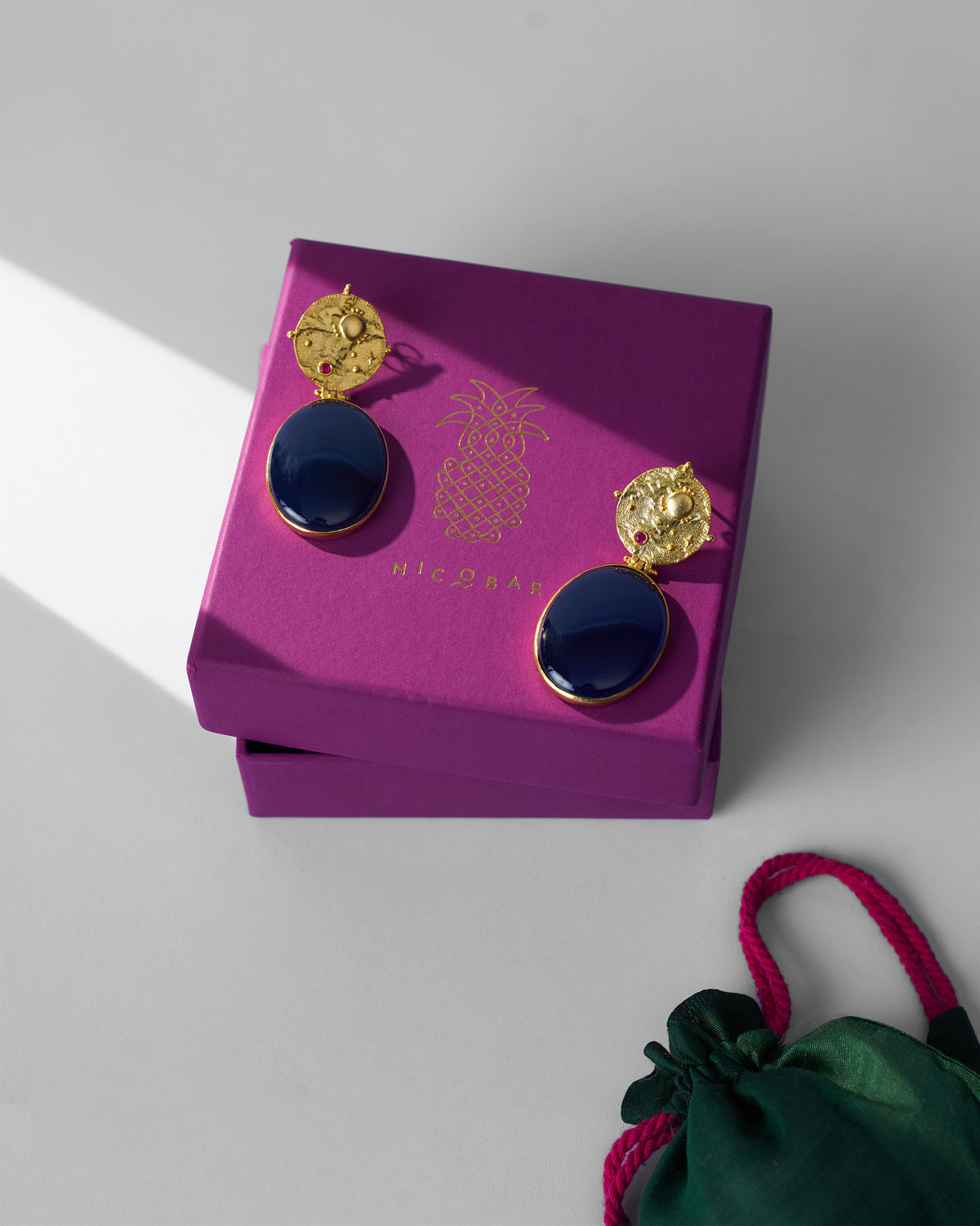 Gold Nebra earrings on a purple Nicobar gift box.