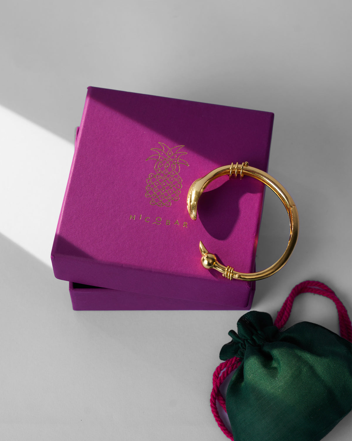 Gold Saras cuff on a purple Nicobar gift box.