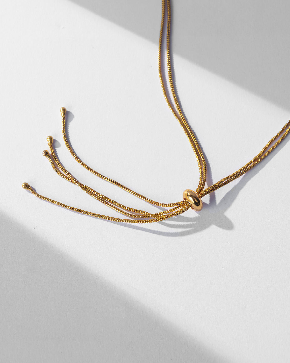 Close-up of the Ahiliya choker gold adjustable slider closure.