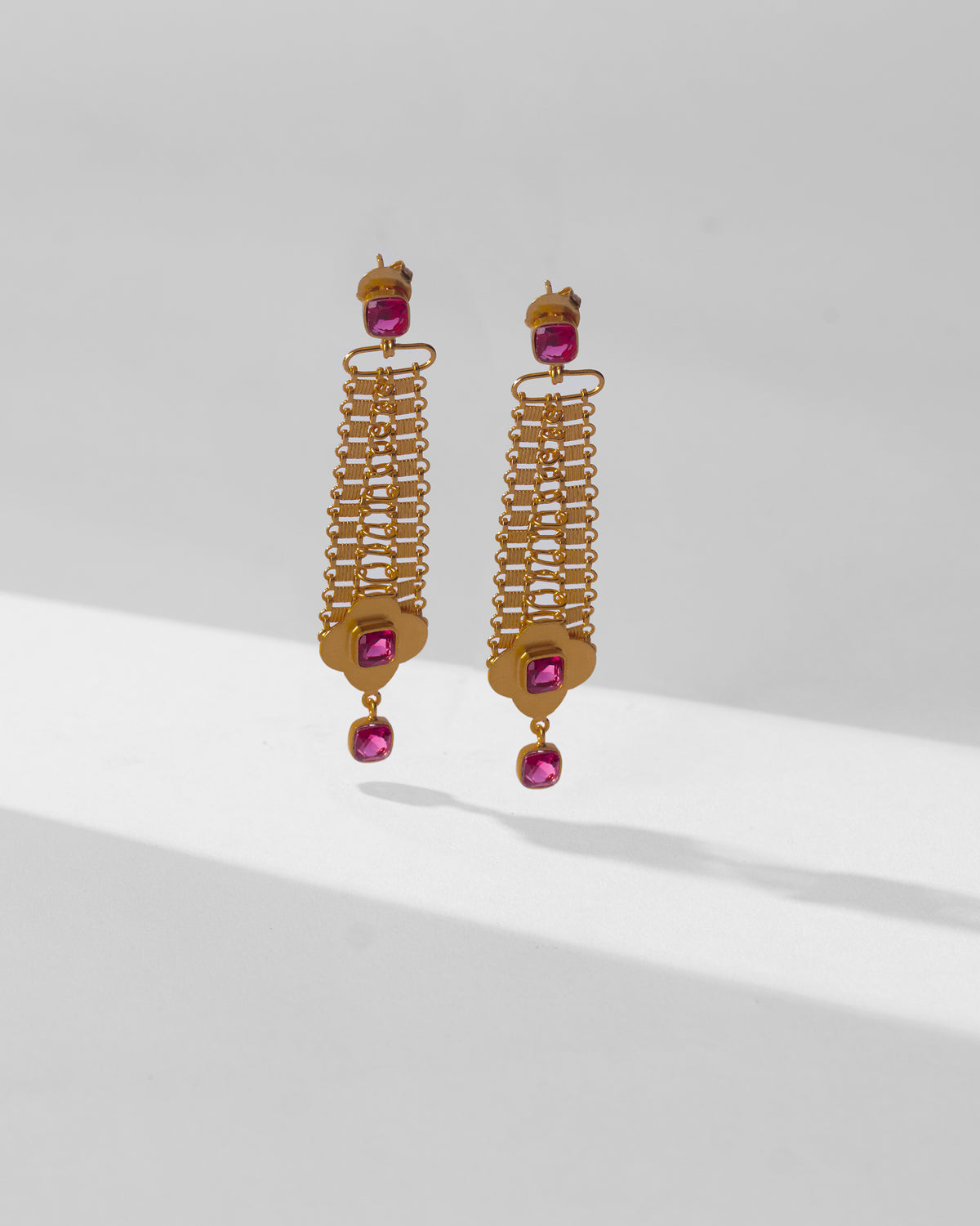 Pair of long gold Ahiliya danglers with ladder mesh and pink glass drops.