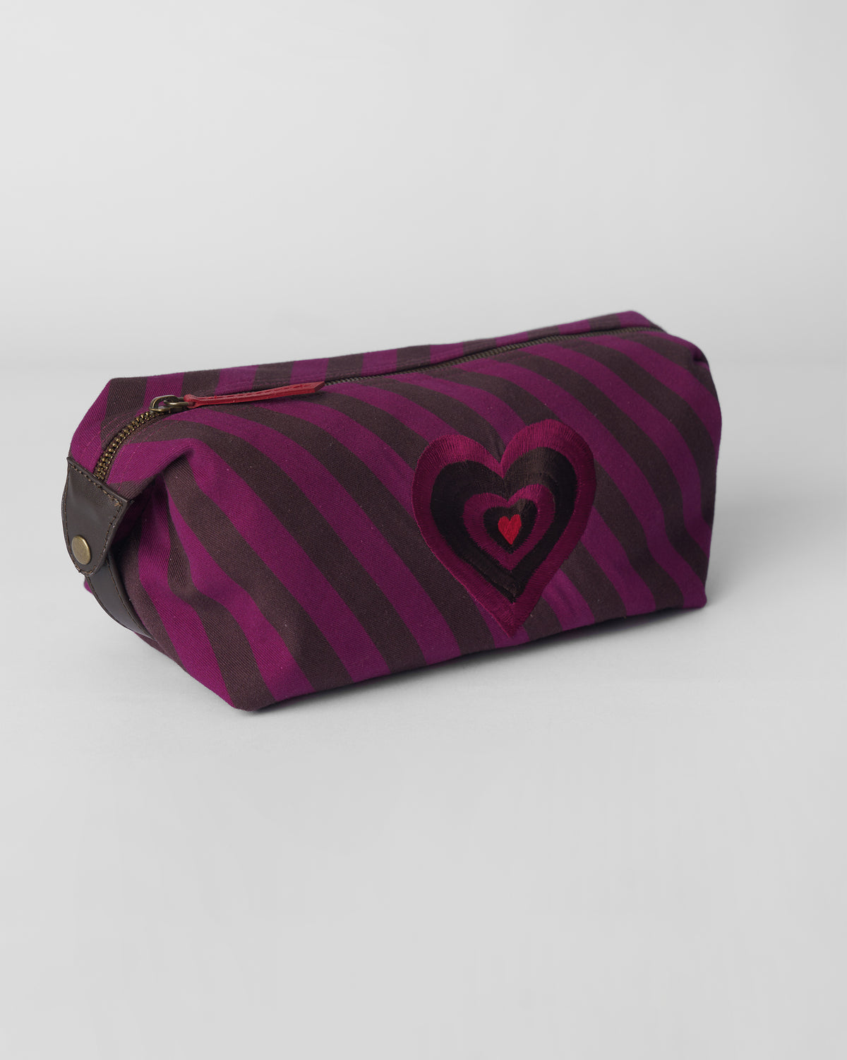 Brown and mulberry Cupid Pouch with a layered heart and red zipper pull.