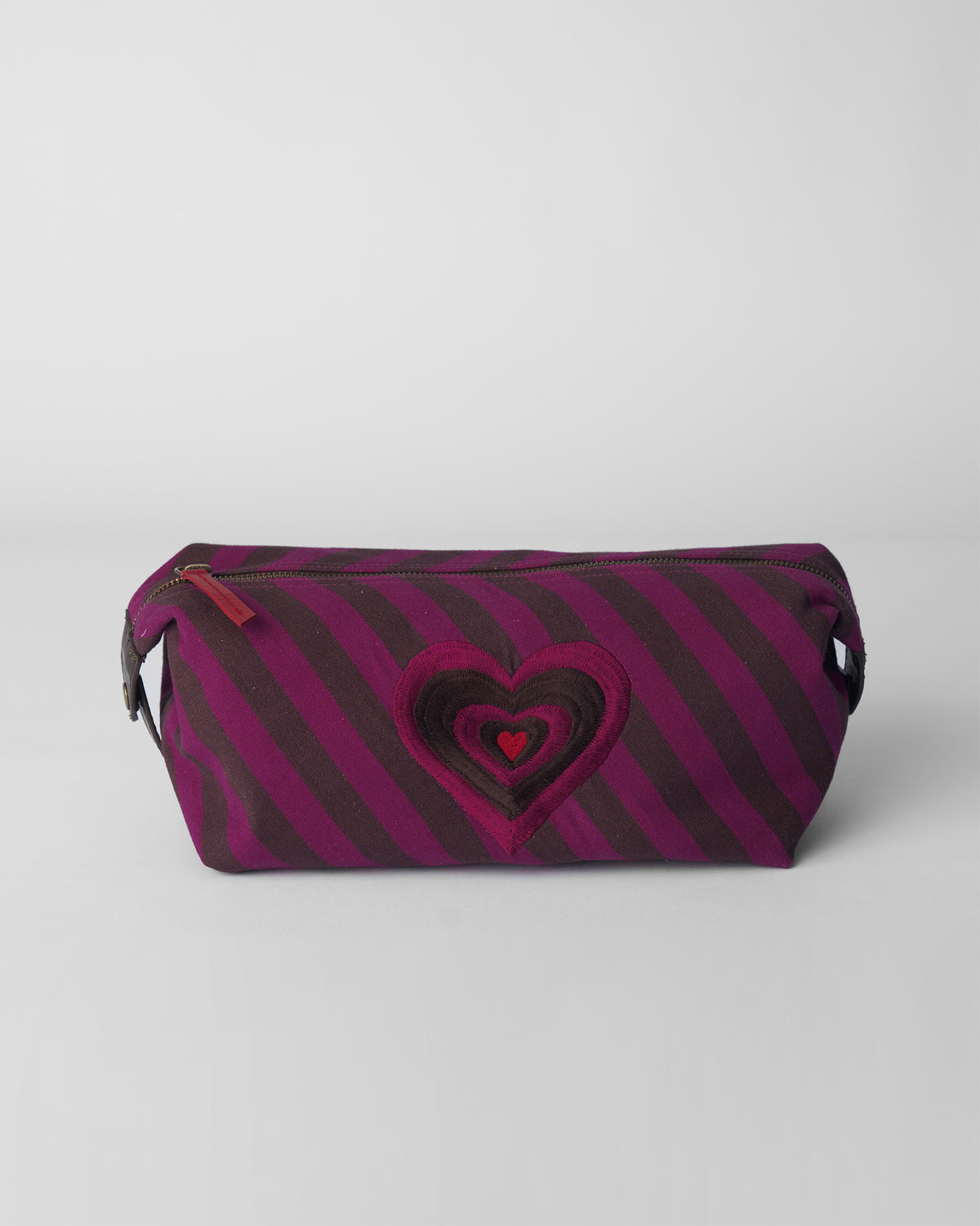 Brown and mulberry striped Cupid Pouch with a concentric heart on the front.