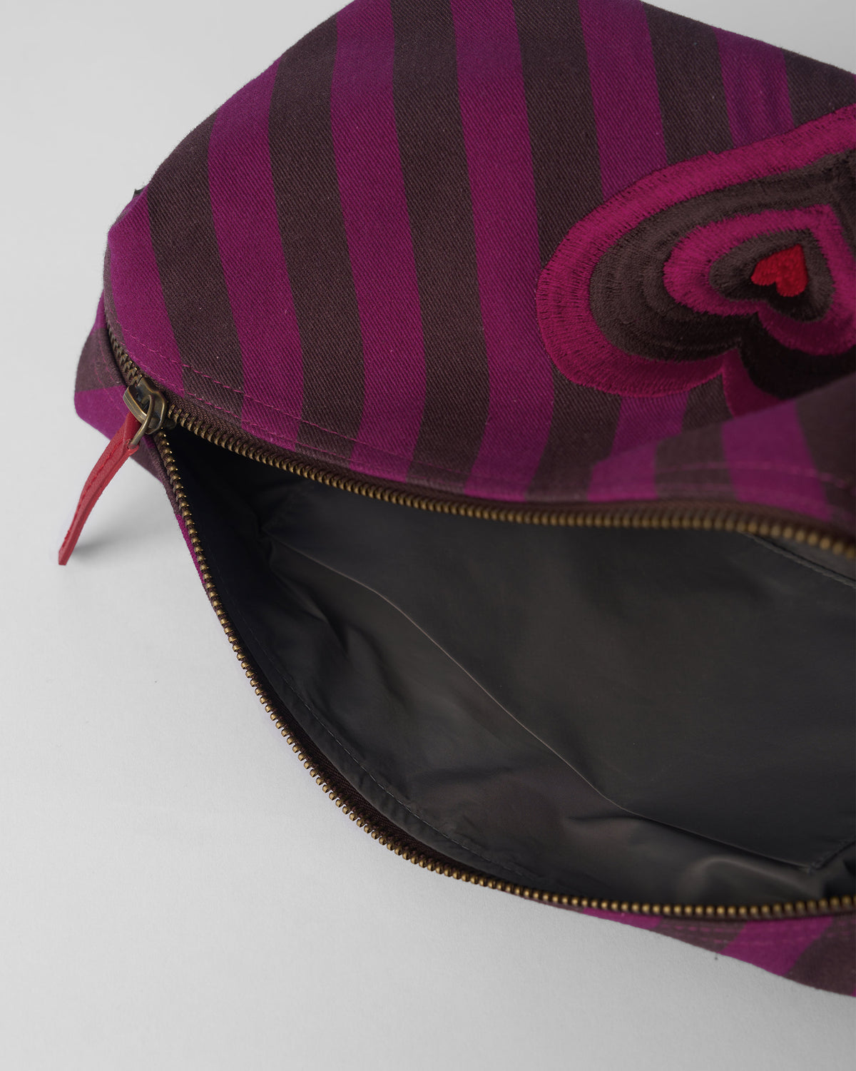 Open brown and mulberry Cupid Pouch showing the lining and heart embroidery.