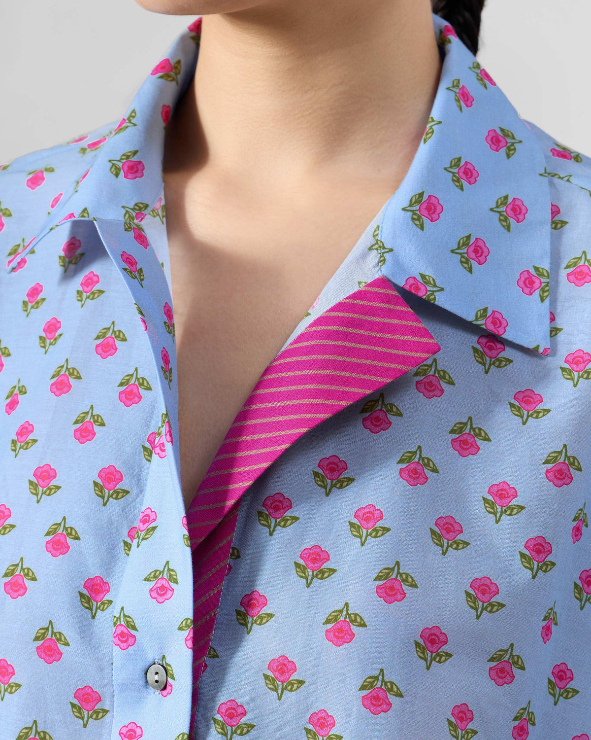 Close-up of the collar and pink striped placket lining on an ice blue Rann shirt.