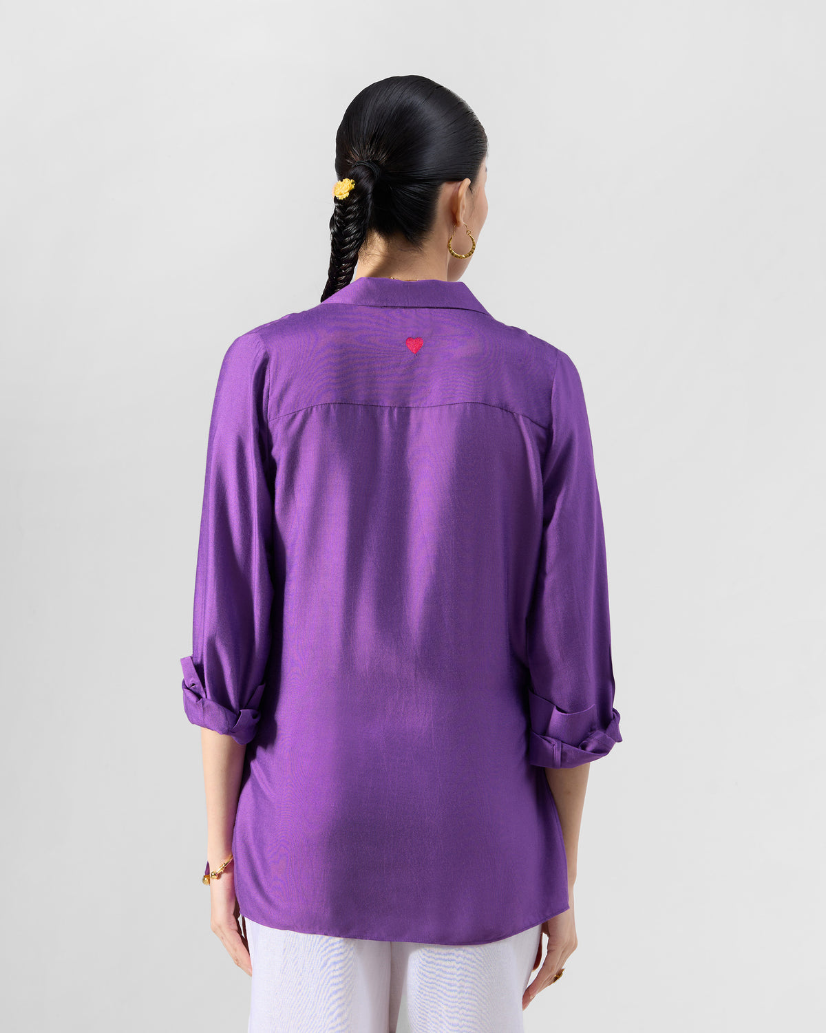 Back of a purple Katya shirt with a small red embroidered heart.