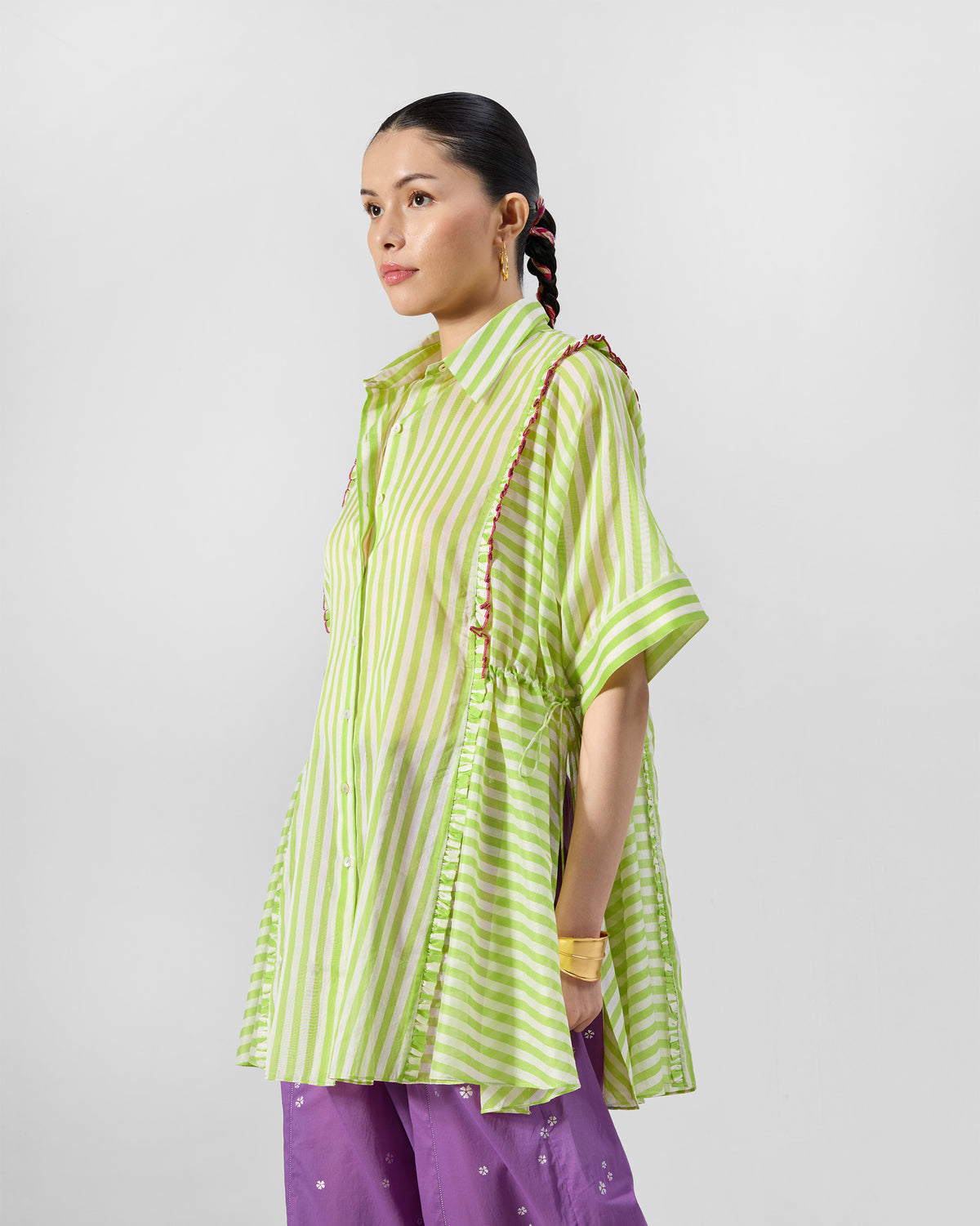 Three-quarter view of a lime striped Manoor Top gathered with side ties.