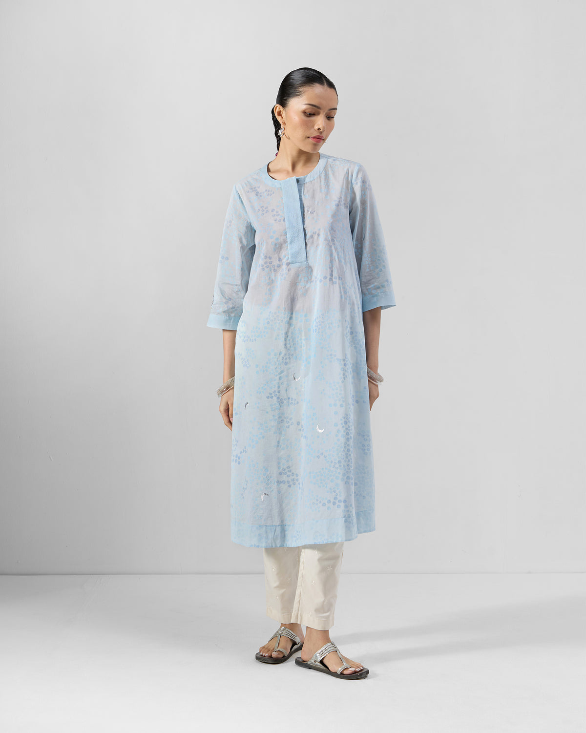 Person wearing a light blue printed kurta with a band collar.
