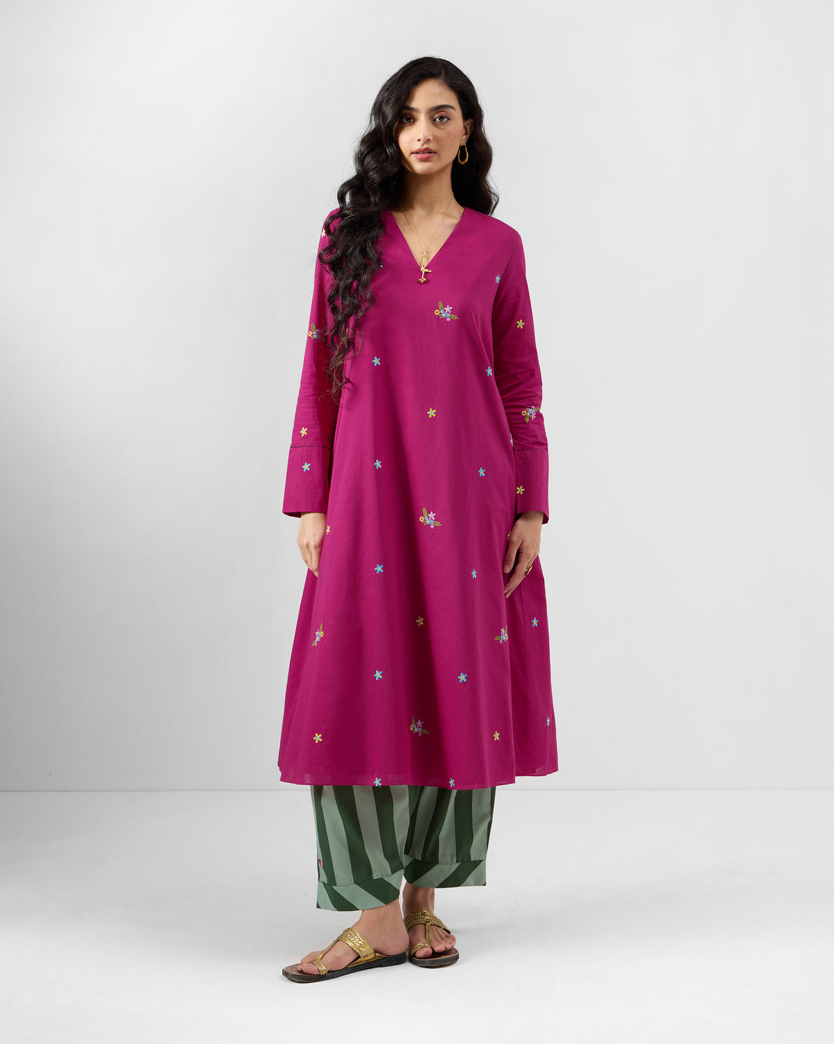 Person wearing a berry pink Narsa kurta with star and floral embroidery.