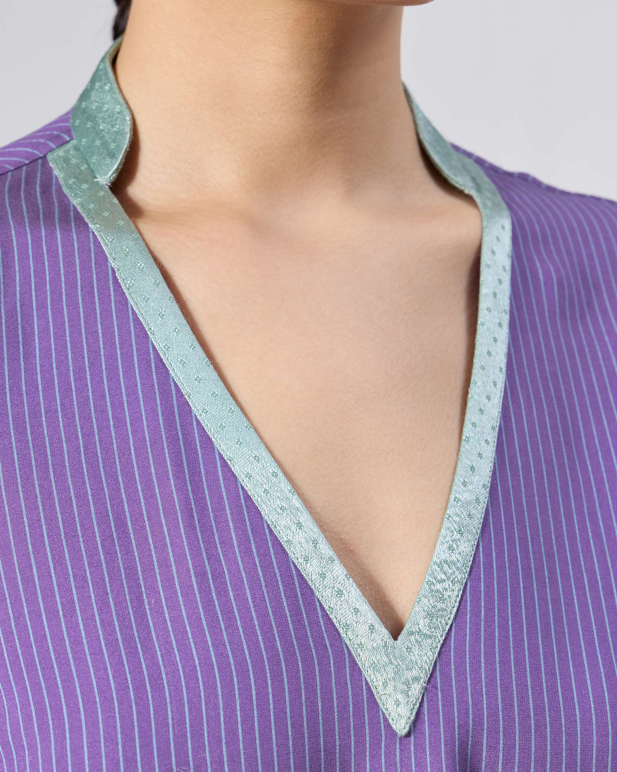 Close-up of a purple striped Hatiya Kurta with ice blue V-neck trim.
