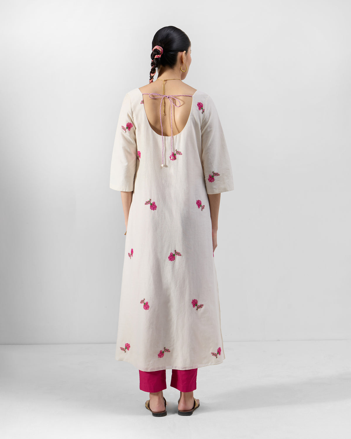 Back of a cream Amrai Kurta with a deep U-back and pink florals.