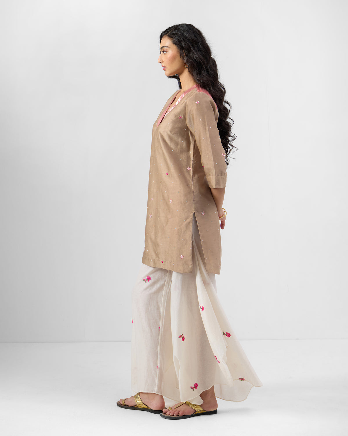 Side view of a sand and soft pink Yeles kurta with scattered embroidery.