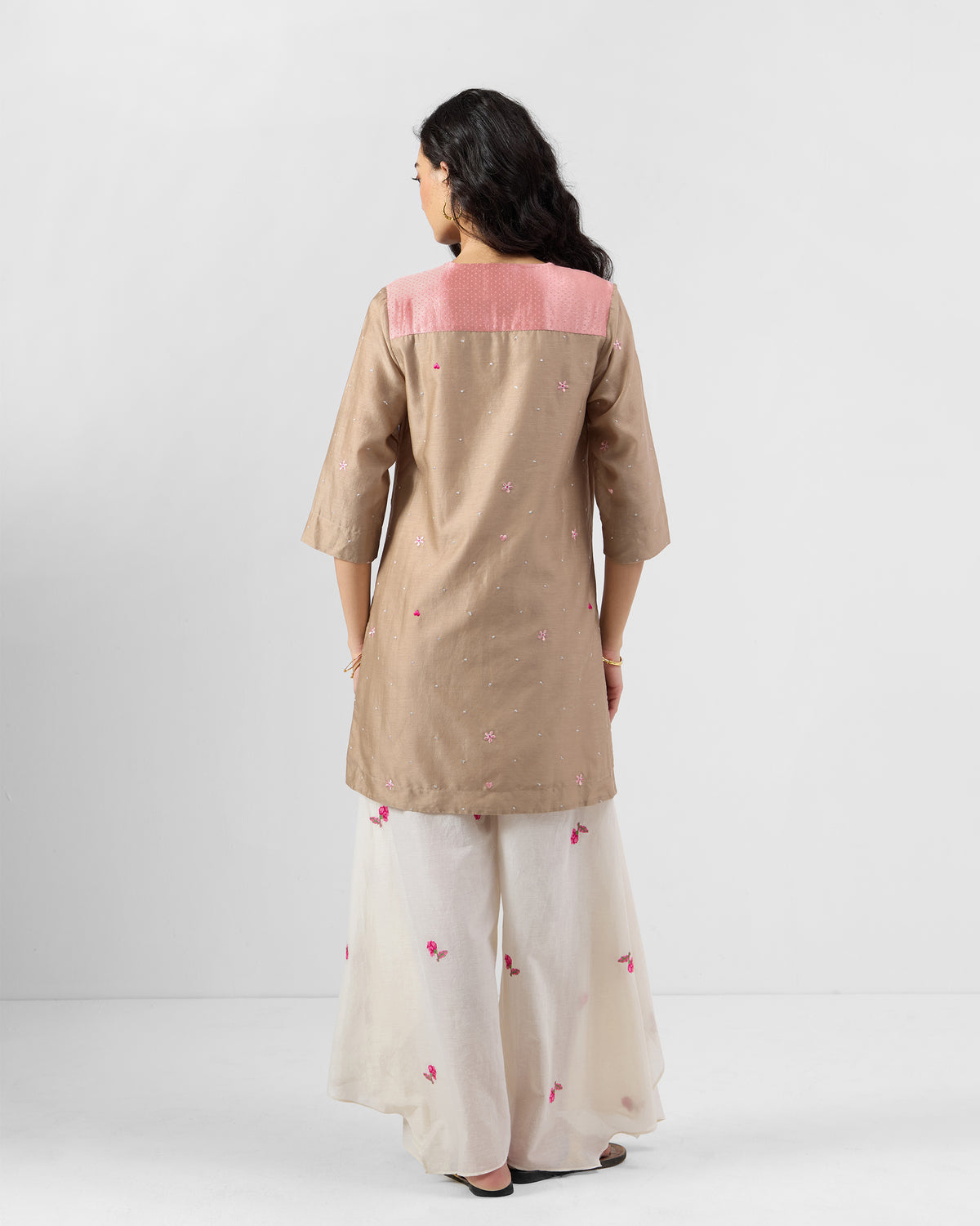 Back of a sand Yeles kurta with a soft pink yoke and floral embroidery.