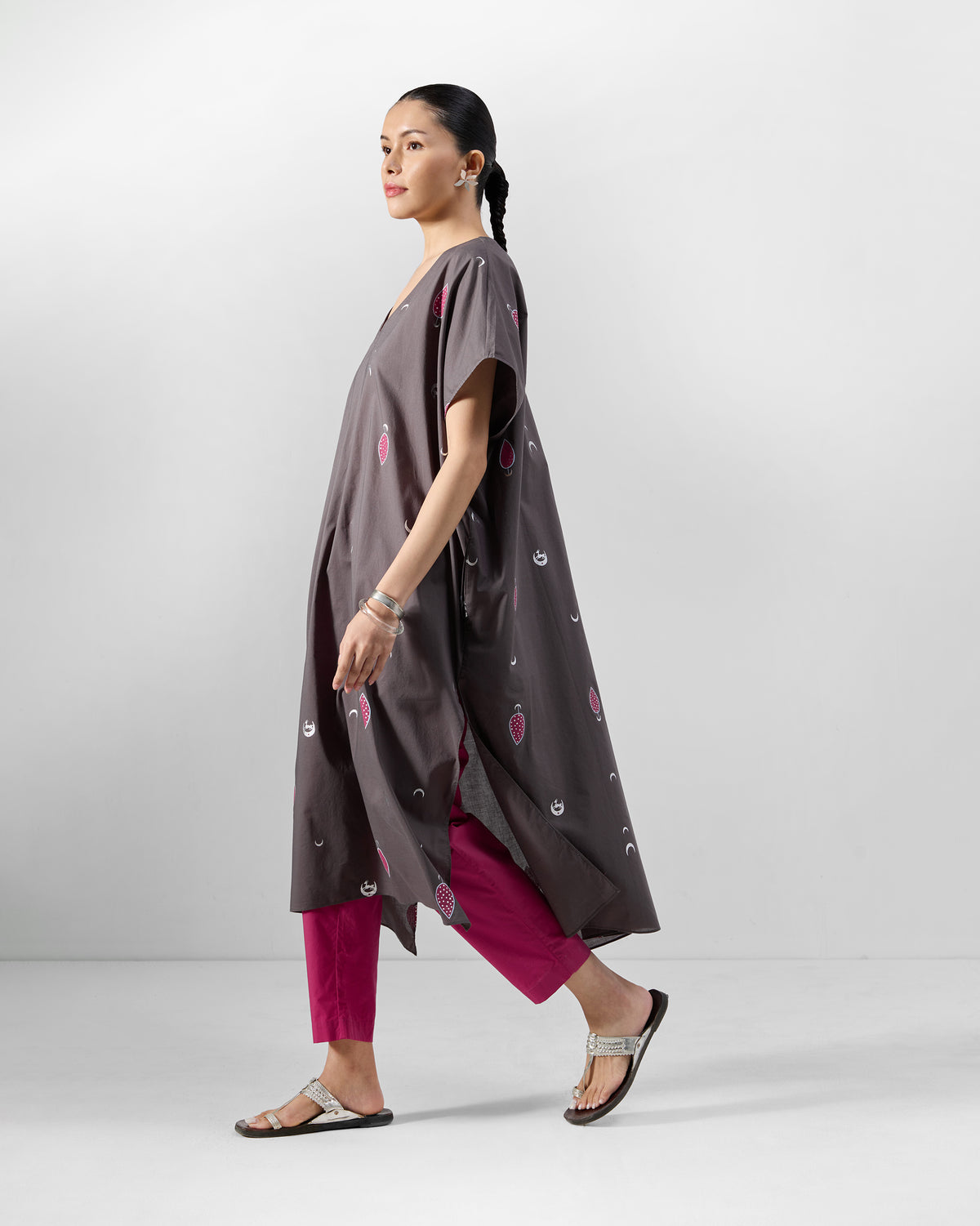 Side view of a charcoal Faye Kaftan with pink motifs and side slits.
