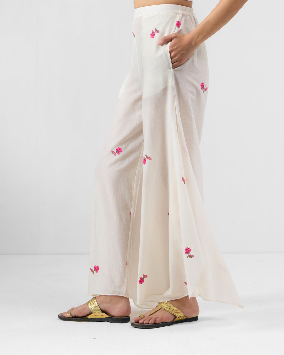 Side view of white Raahi pants showing a wide A-line drape.