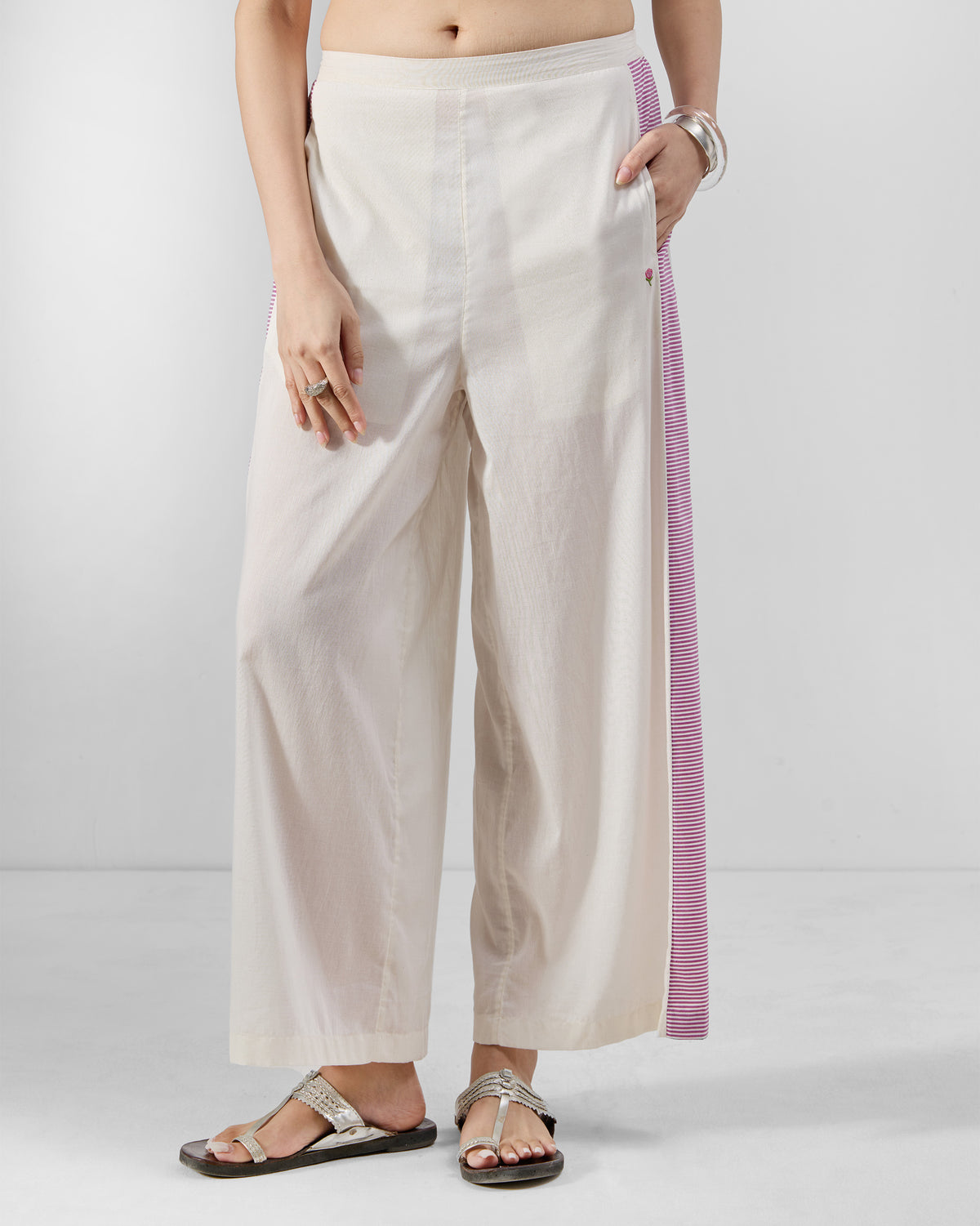 Ivory Nadi pants with a purple striped side panel and side pockets.