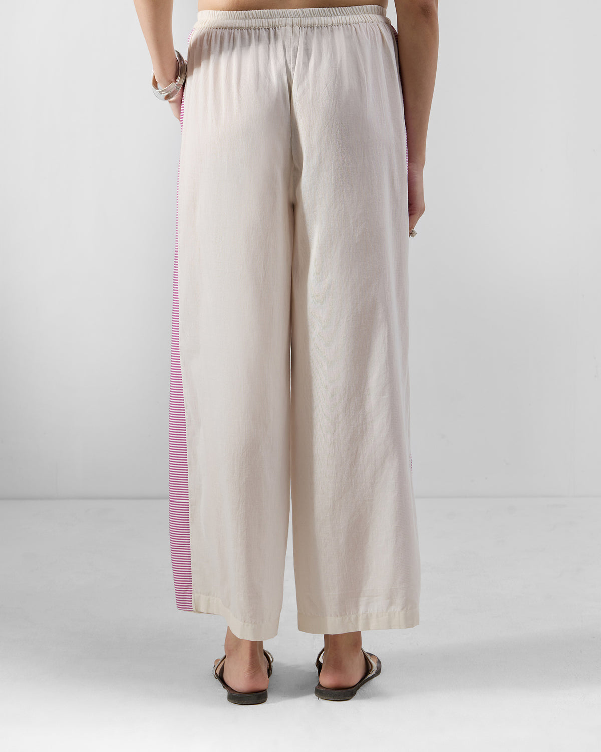 Back of ivory Nadi pants with an elastic waist and striped side panel.