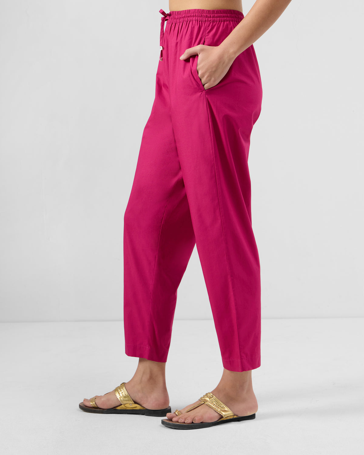 Side view of berry pink Kintara pants with a tapered ankle length.