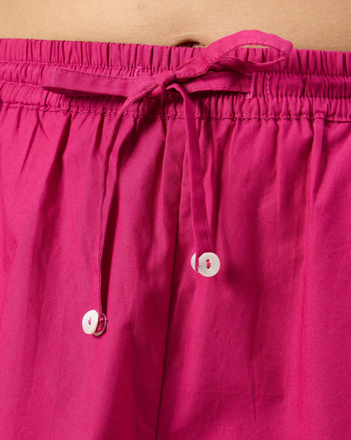 Close-up of the drawstring waistband on berry pink Kintara pants.