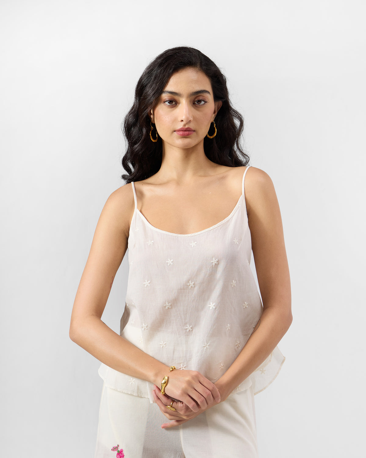 Ivory embroidered Lola slip with a scoop neck and thin straps worn by a person.