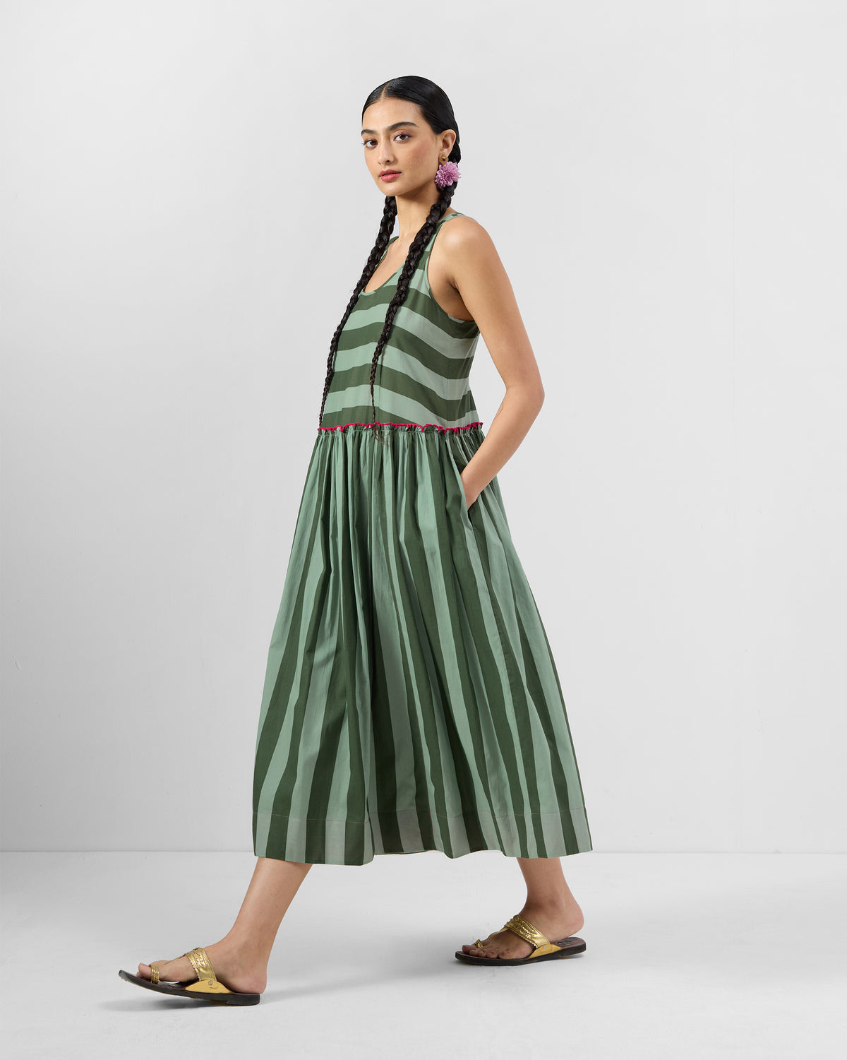 Side view of a dark green and olive Nora racerback dress with pink waist trim and a side pocket.