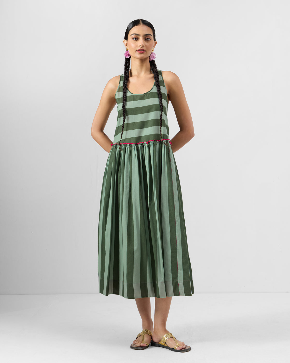 Person wearing a dark green and olive Nora racerback dress with pink waist trim.