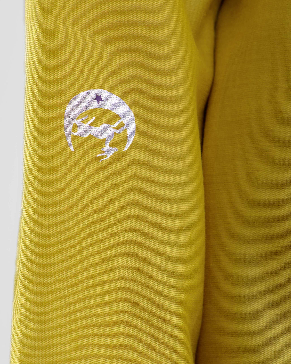 Close-up of a chartreuse Boat Neck Kurta with a white crescent motif.