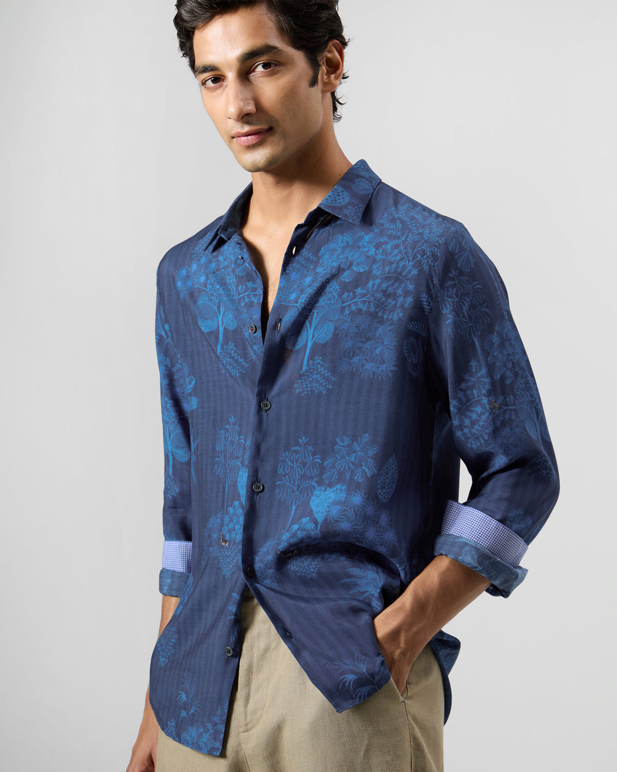 Person wearing a navy Hakuna shirt with a tonal blue botanical print.