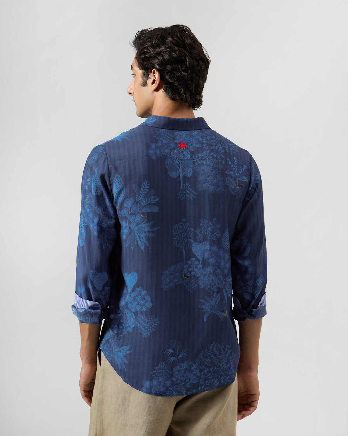 Back of a navy Hakuna shirt with a small red star on the yoke.