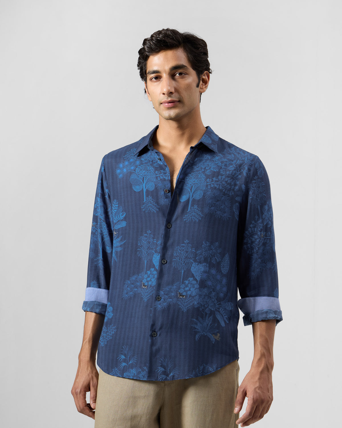 Person wearing a navy Hakuna shirt with sleeves rolled up.