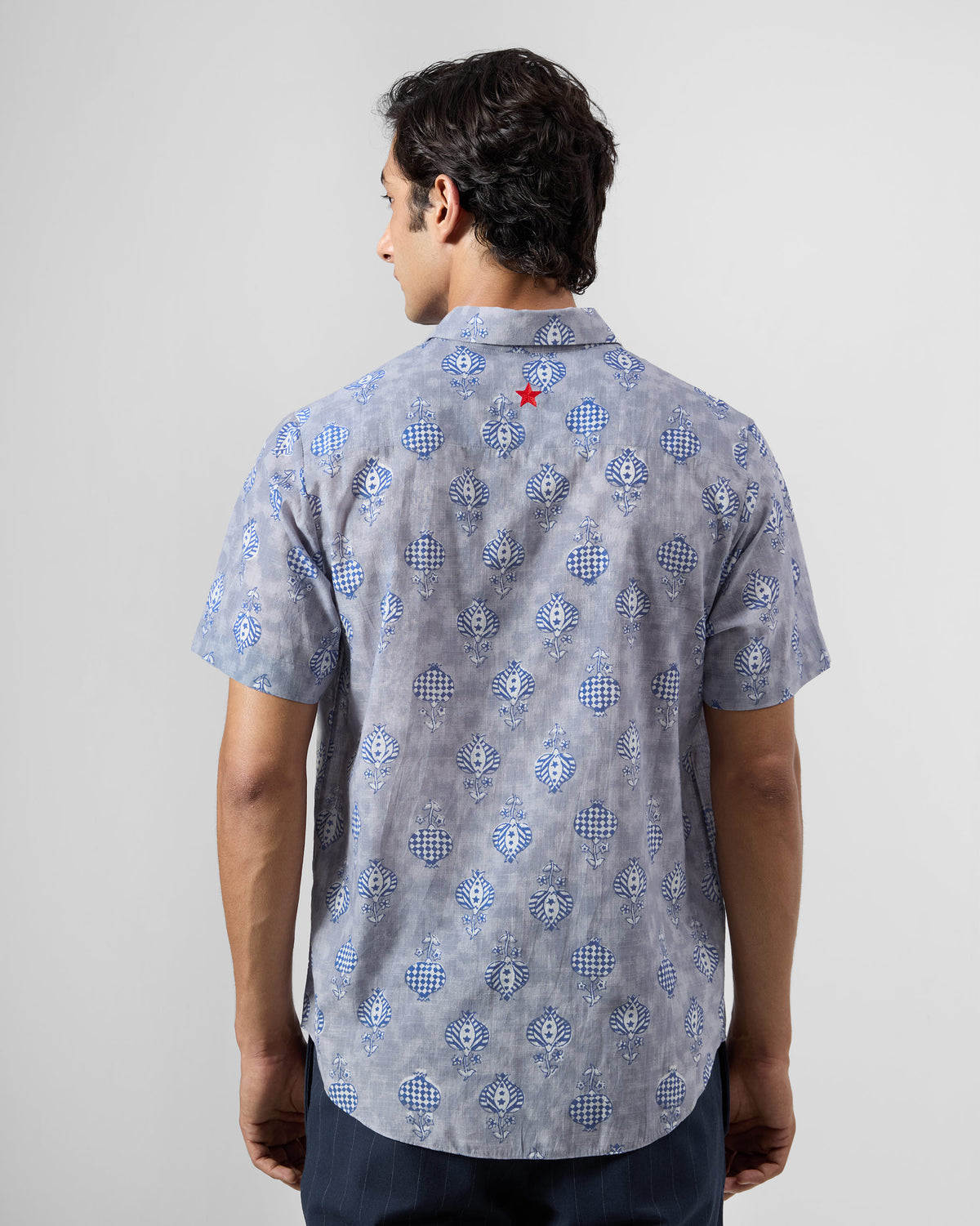 Back of a light blue Ganga Shirt with a red star below the collar.