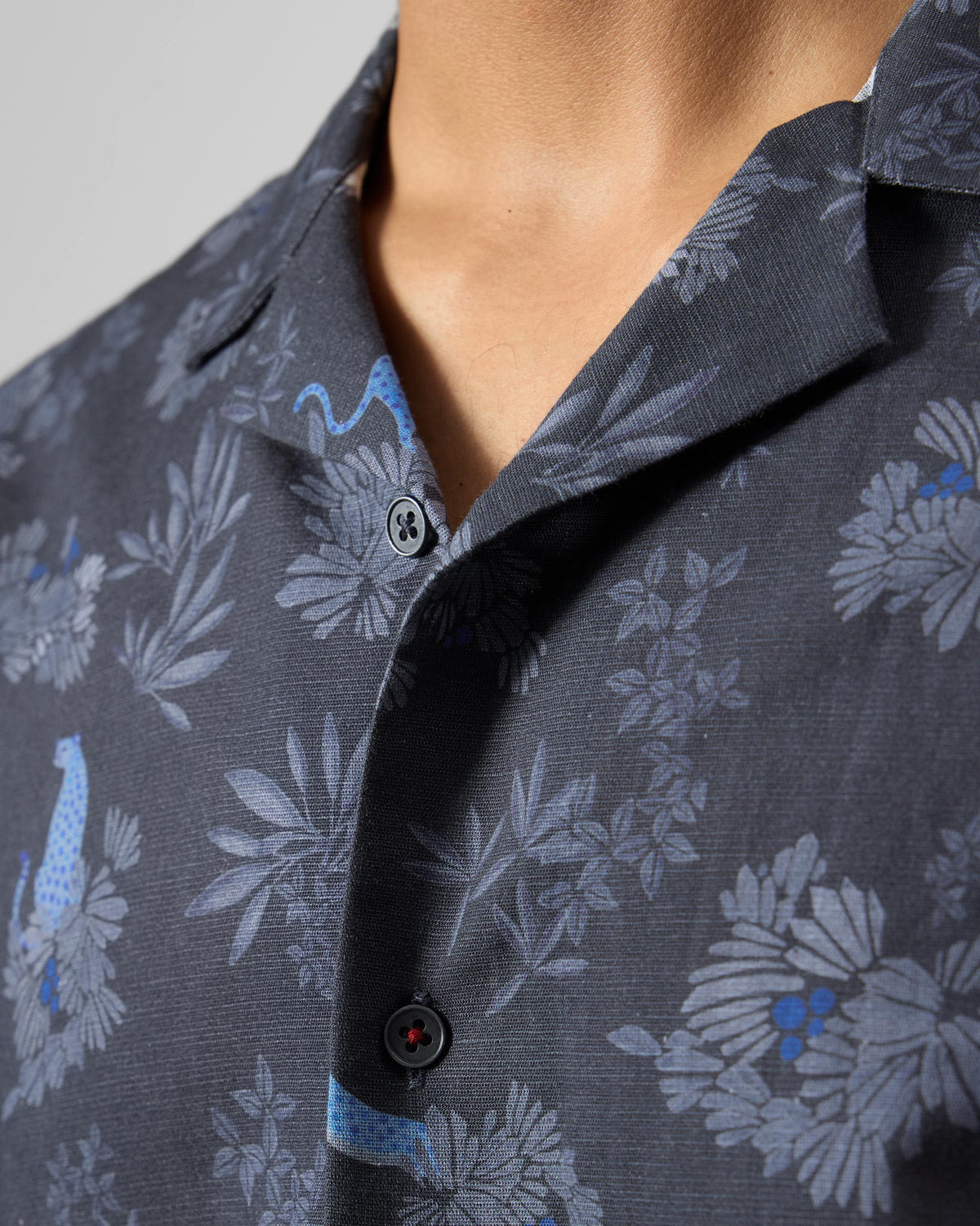 Close-up of a charcoal Mistari Shirt showing blue leopard print and camp collar.