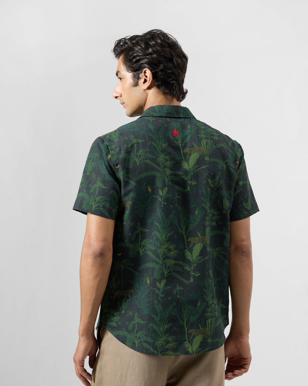 Back of a green Half Sleeve Shirt with a jungle print and red star.