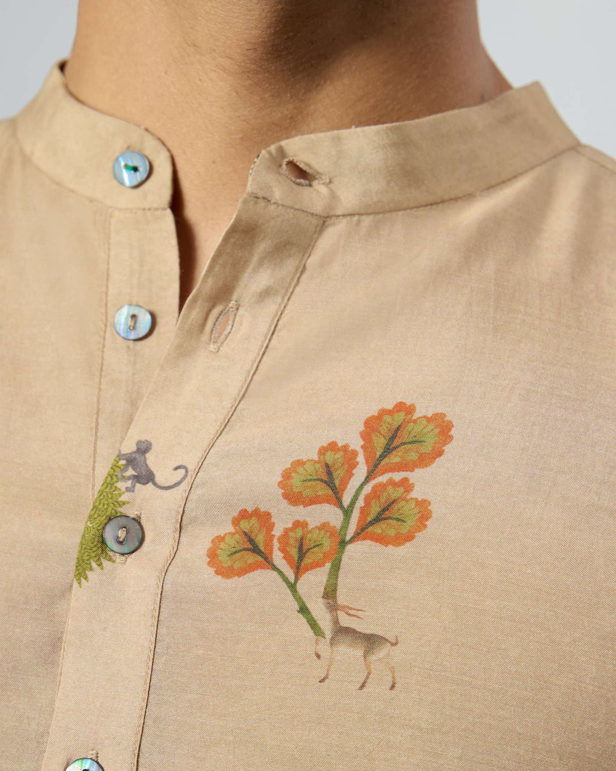 Close-up of a beige Bageecha kurta collar with tree and animal print.