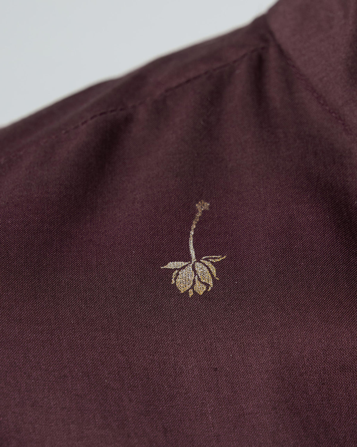 Close-up of a gold floral foil motif on a wine Rey Kurta.