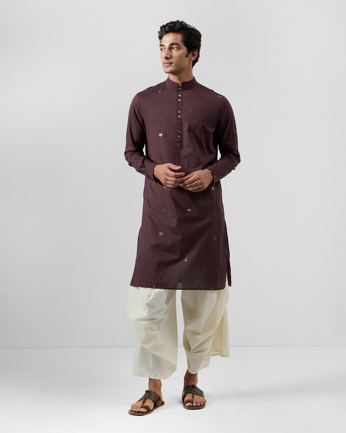 Person wearing a full-length wine Rey Kurta with scattered foil motifs.