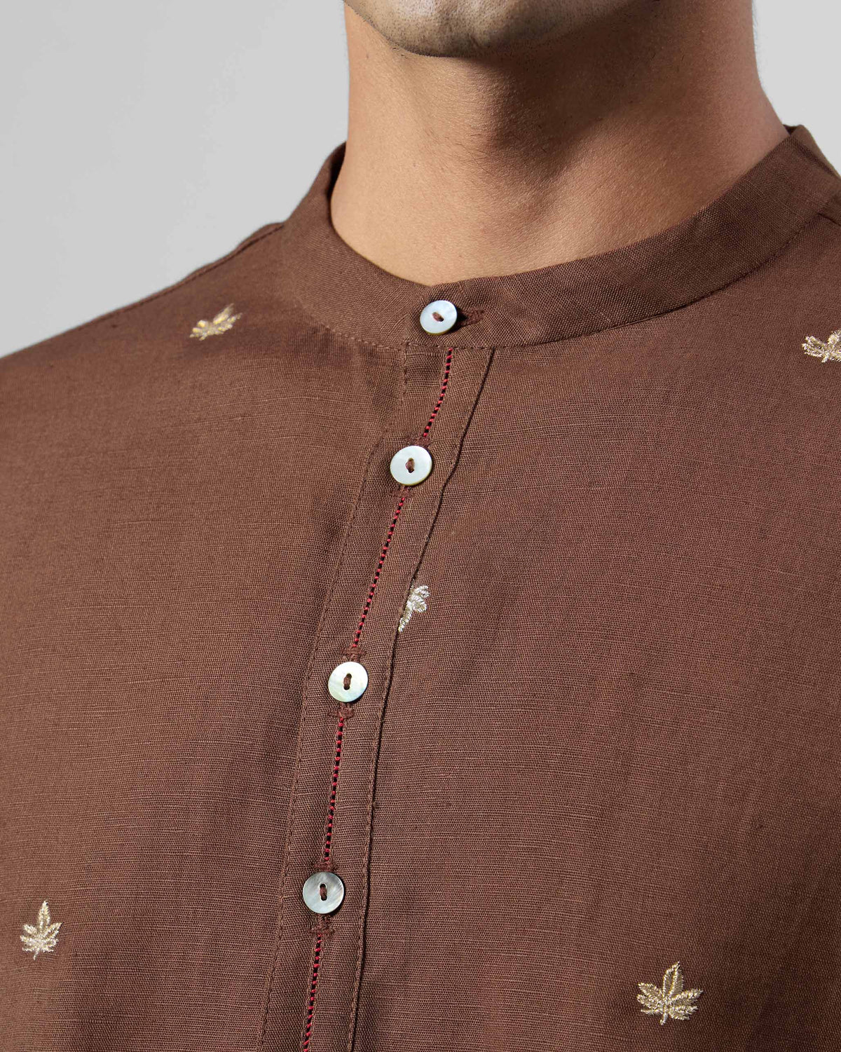 Close-up of Astral kurta band collar with red faggoting and leaf embroidery.