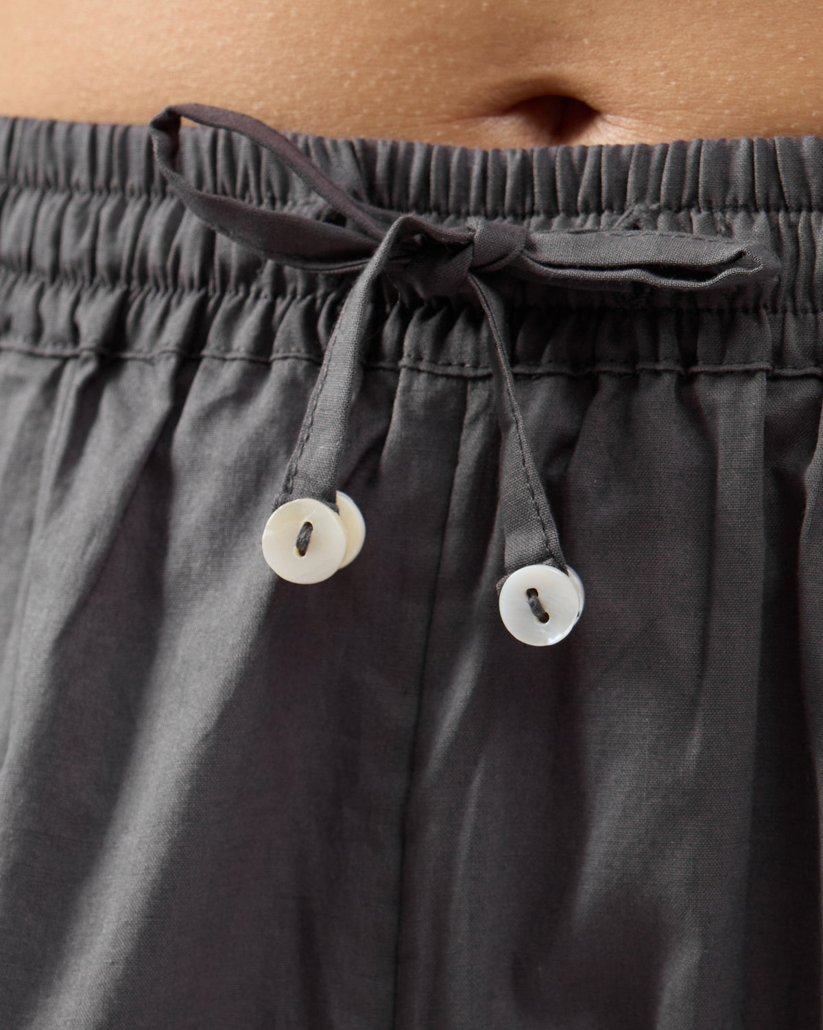 Close-up of the drawstring waistband on charcoal Narrow Pants.