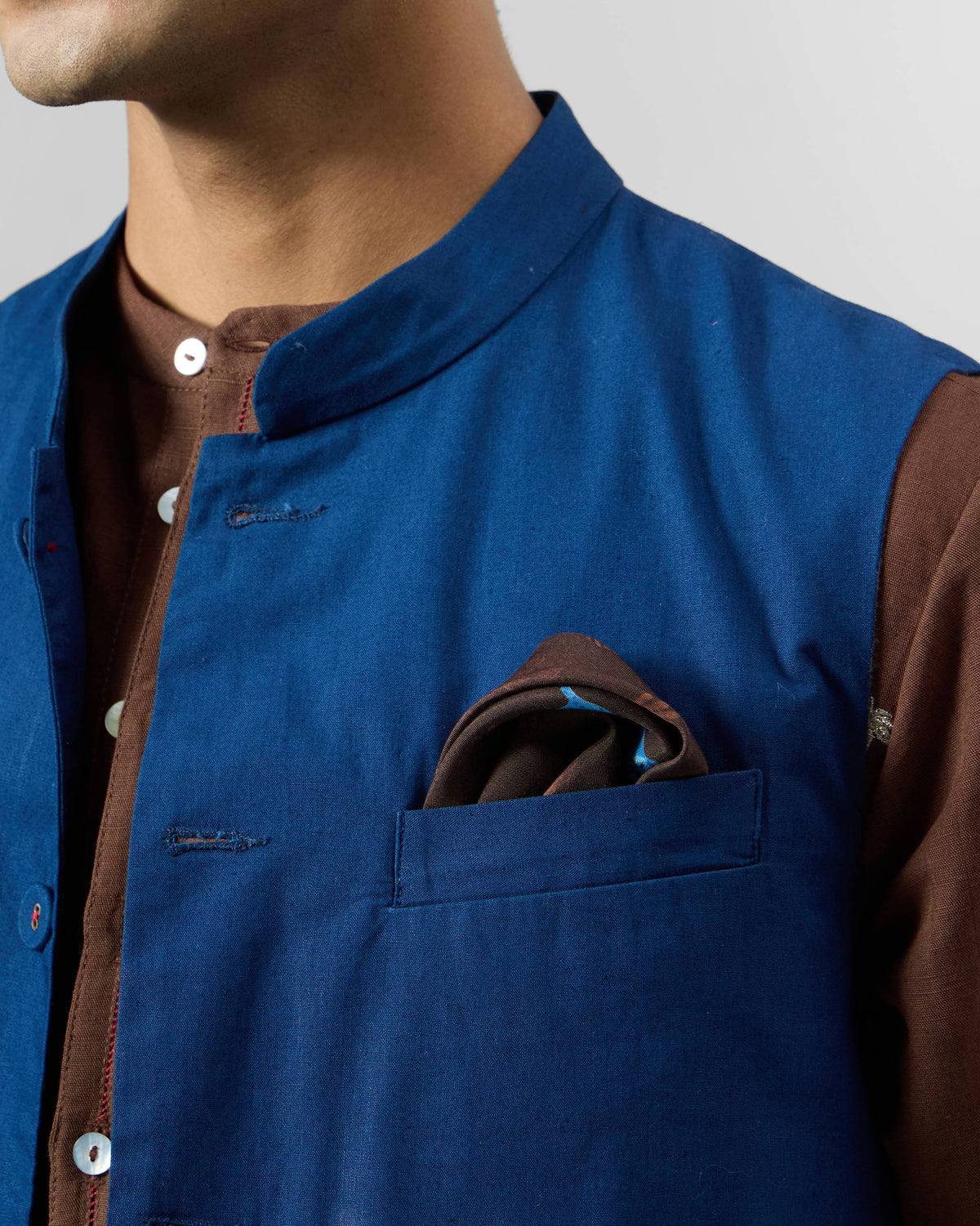Brown tiger pocket square tucked in the breast pocket of a blue Nehru vest.